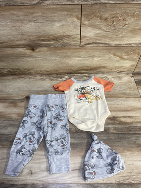 Top-down of 3-piece Mickey set: cream onesie with orange sleeves and 'Best Pals', gray Mickey pants and hat on wood