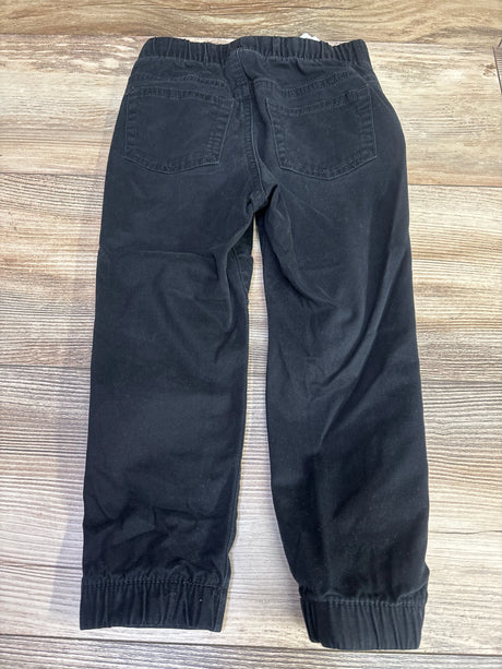 Back view of Cat & Jack black drawstring joggers in size 3T showcasing two rear pockets and elastic cuffs on a wood surface