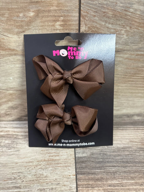 Two brown grosgrain hair bows on a black Me n Mommy To Be packaging card.