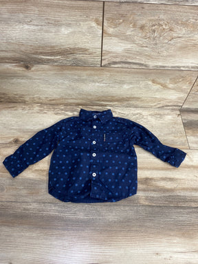 Navy blue polka dot long sleeve toddler shirt with buttons on wooden floor