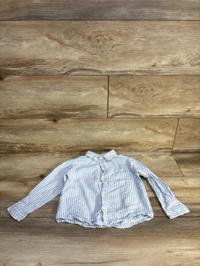 Light blue and white striped long sleeve button-up shirt for toddlers on wood background