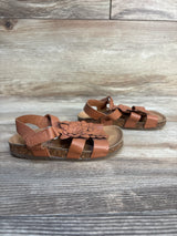 Brown toddler sandals with floral decoration and cork soles on wood background