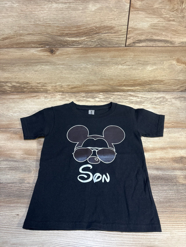 Black kids t-shirt with cartoon mouse face in sunglasses and 'Son' text, laid on wood