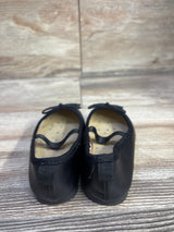 Rear view of Cat & Jack Nora toddler black slip-on ballet flats showing elastic strap and bow on wood-look floor