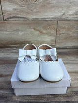 Front view of Rinsvye leather princess flat showcasing bow and scalloped trim on a white shoebox with wood floor background