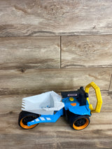 Matchbox toy dump truck with white bucket, blue body, black and orange wheels, and yellow handle on wood surface