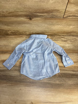 Light blue long sleeve button-up toddler shirt on wood floor, gently used kids clothing