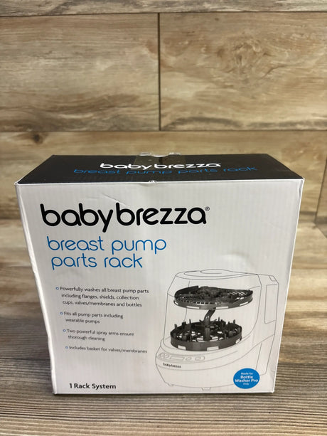 Front view of Baby Brezza breast pump parts rack box showing two-tier rack illustration, branding, and feature text on wood background