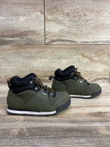Pair of toddler hiking boots in green and black with yellow laces on wooden floor
