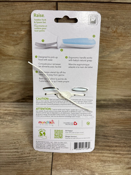 Back view of Munchkin Raise toddler fork and spoon set showcasing ergonomic handle and tip up bases with wood background
