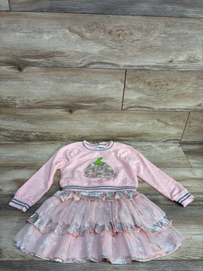 Pink toddler outfit with long sleeve top featuring a pumpkin design and a layered glittery tutu skirt on wood floor