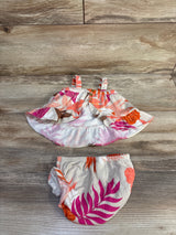 Flat lay of Carter's 2-piece floral tank and bloomers in beige with pink leaf print, ruffle hem and elastic waist on wood
