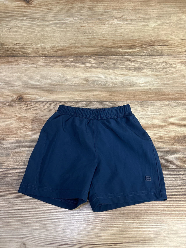 Flat lay of navy toddler active shorts size 12 months showing elastic waistband and embroidered 8 logo on wood floor background