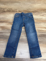 Blue denim kids jeans laid flat on wooden surface, gently used children's clothing