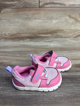 Side view of pink See Kai Run sneakers size 4C with mesh upper, hook-and-loop strap and white sole on wood surface