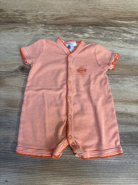 Orange and white striped baby romper with buttons, short sleeves, on wood background