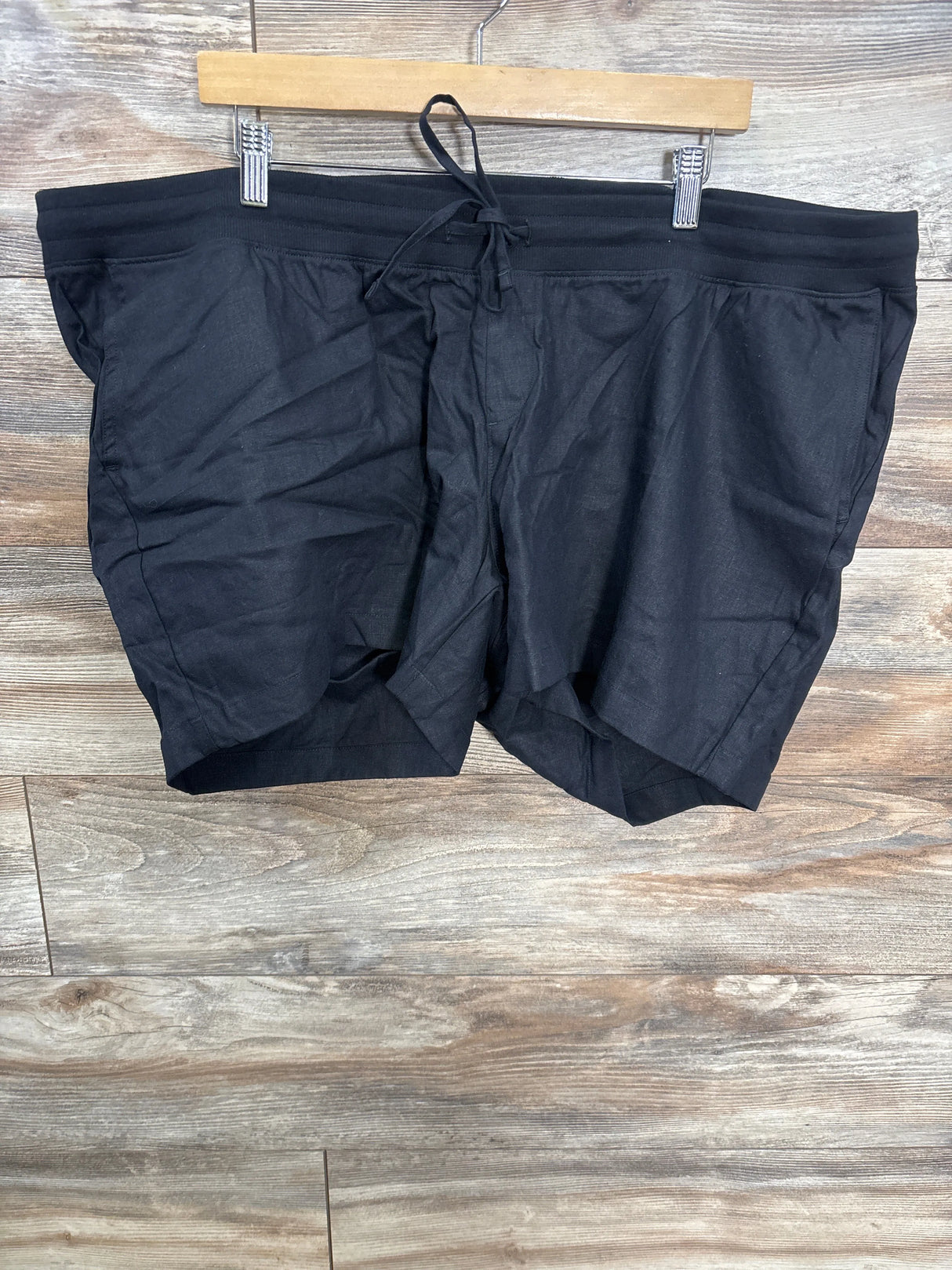 Black drawstring maternity shorts on wooden hanger, gently used kids clothing resale