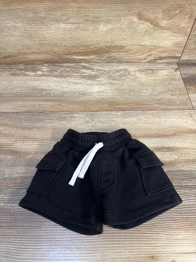 Black toddler cargo shorts with white drawstring on wood floor