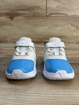 Toddler white and blue athletic sneakers with velcro straps on a wooden surface
