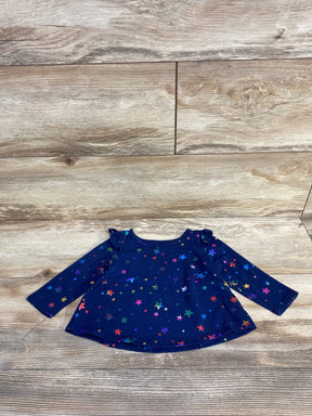 Navy blue long-sleeve baby shirt with colorful star print laid on wooden floor