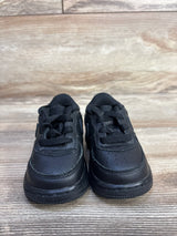 Front view of Nike Air Force 1 06 TD Triple Black toddler sneakers showcasing perforated leather uppers sz 4c on wood plank floor