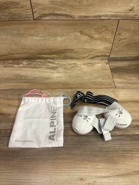 Top view of white Alpine Muffy Baby ear muffs with carrying pouch and headband on a wood floor