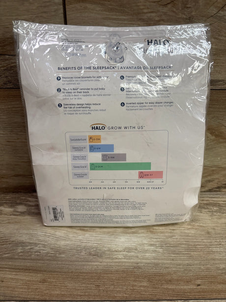 Back view of a cream Halo SleepSack 0.5 TOG wearable blanket showcasing sleep safety benefits and growth chart on wood flooring