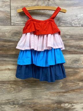 Front view of tiered toddler dress with red, pink, bright blue and navy tiers on wooden hanger against wood plank background