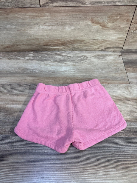 Top view of toddler pink terry shorts showing elastic waistband and soft terry texture on wood floor background