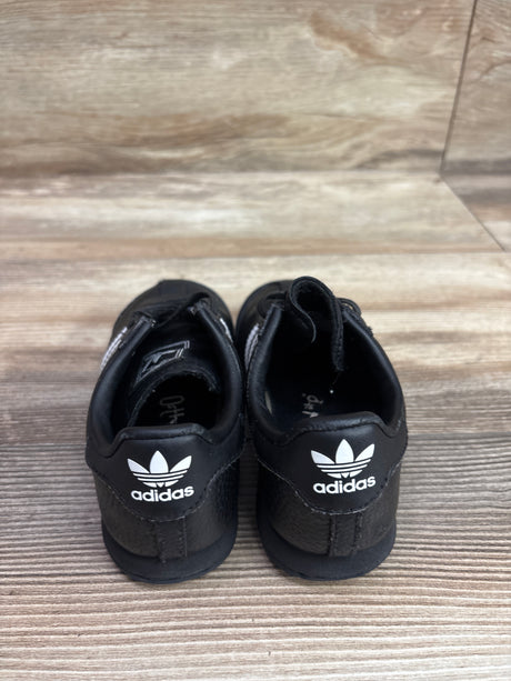 Rear view of a pair of black Adidas Samoa I sneakers, size 10C, showcasing white Adidas logos on a wood floor