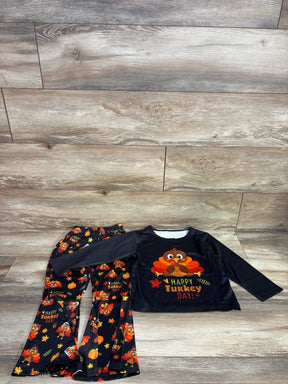 Kids Thanksgiving outfit with Happy Turkey Day shirt and turkey print pants on wood floor
