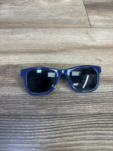Front view of kids' blue plastic sunglasses showing rectangular frame and dark lenses on wood tabletop