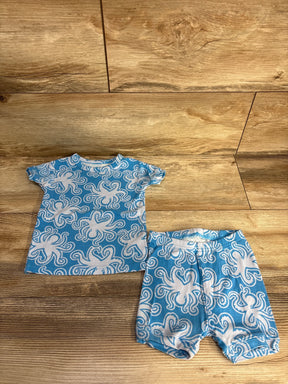 Blue and white baby outfit with octopus pattern, short sleeves and shorts on wood floor