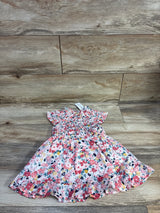 Flat lay of Janie and Jack pink floral toddler dress showcasing ruffle trim and smocked bodice with matching bloomers on wood floor