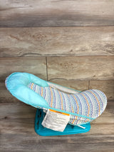 Side view of Summer Infant Foldaway baby bather showing aqua seat, multicolor insert and turquoise base on wood floor
