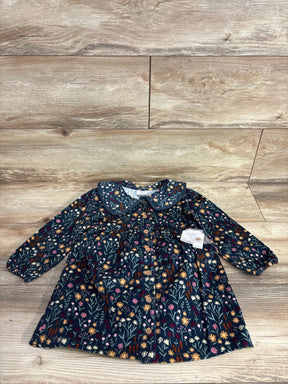 Long sleeve toddler dress with floral print, button front, and Peter Pan collar on wood floor