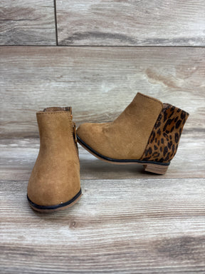 Children's tan suede ankle boots with leopard print heel detail on wooden floor