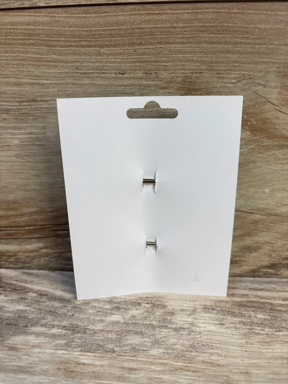 Front view of 2-pack brown hair bows backing card showing two silver alligator clips on light wood background