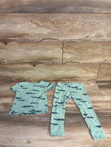 Flat lay of sage ribbed 2-piece toddler pajama set showing top and leggings with navy alligator print on wood floor