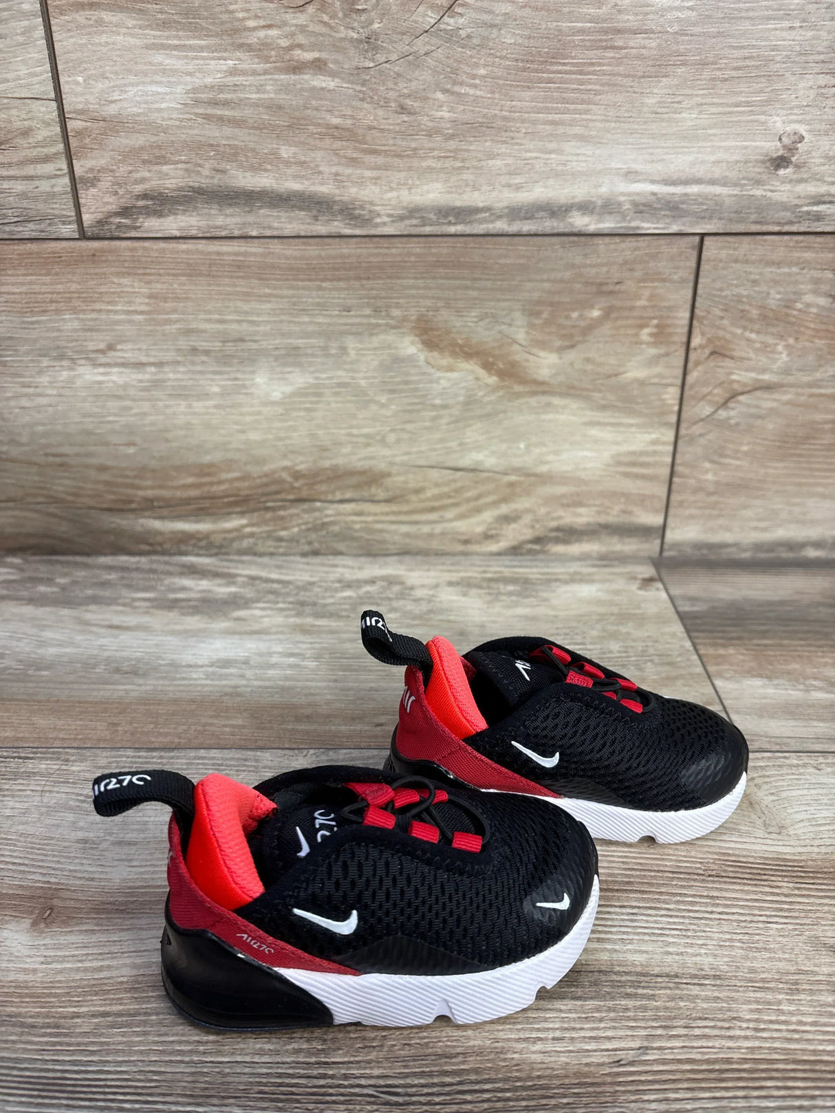 Angled view of Nike Air Max 270 Bred toddler sneakers size 4C with mesh upper and visible heel air on wood floor