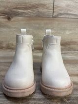 Front view of Cat & Jack Chelsea toddler boots in beige showing side zipper and pink rubber sole on wood floor background