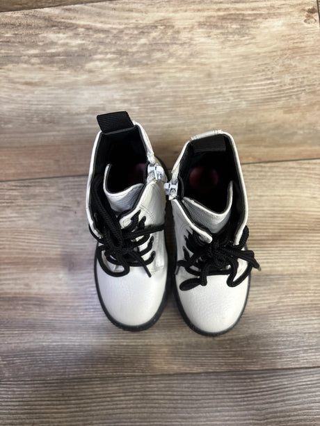 Top view of Sincerely Jules white faux-leather combat boots showcasing black laces and soles on a wood floor