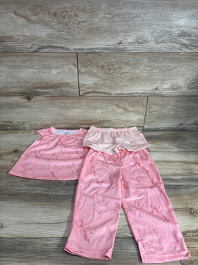 Flat lay of pink 3-piece unicorn pajama set showing ruffled top, elastic-waist shorts and pants on wood background