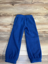 Blue fleece toddler pants with elastic waistband and cuffs on wood floor
