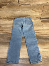 Light wash kids jeans with cuffed hems, laid flat on wood floor for resale