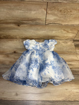 White and blue floral baby dress with puff sleeves on wood floor