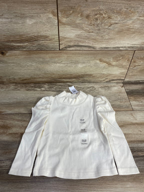Ivory long sleeve toddler shirt with puff shoulders, size 18-24 months, on wood background