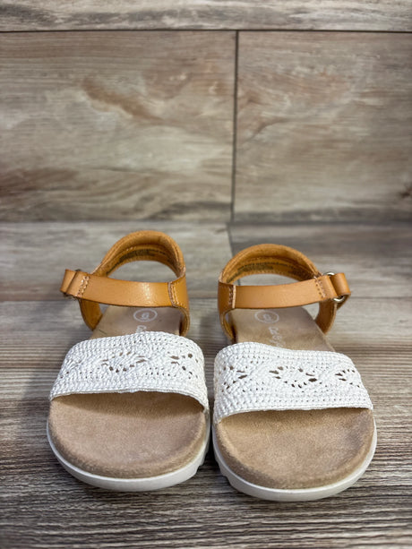 Front view of Cat & Jack toddler Blair strap footbed sandals showcasing tan ankle straps and white crocheted toe bands on wood floor background