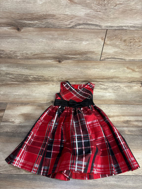 Red plaid sleeveless toddler dress with black bow, laid flat on wood floor