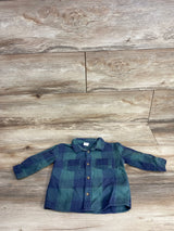 Toddler-sized blue and green plaid long-sleeve button-up shirt laid flat on wood floor